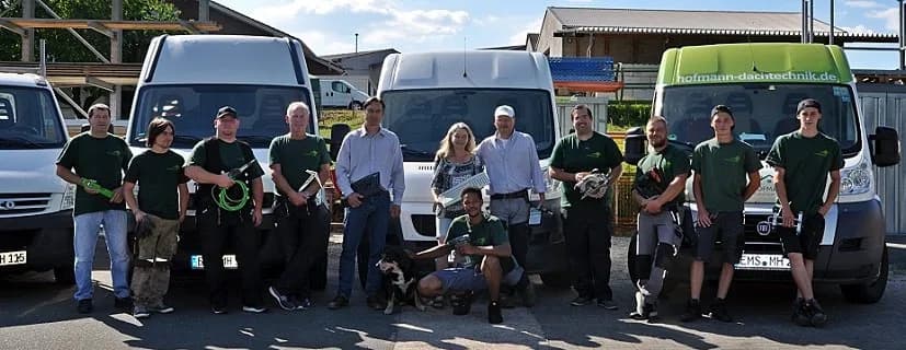 Das Team von Hofmann Dachtechnik vor dem Fahrzeugpark am Betriebshof in Singhofen